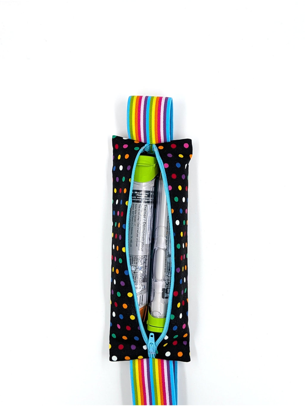 The Daydreamer EpiPen pouch in a black confetti dot print with the rainbow elastic strap, open with an auto-injector and an Emerade inside