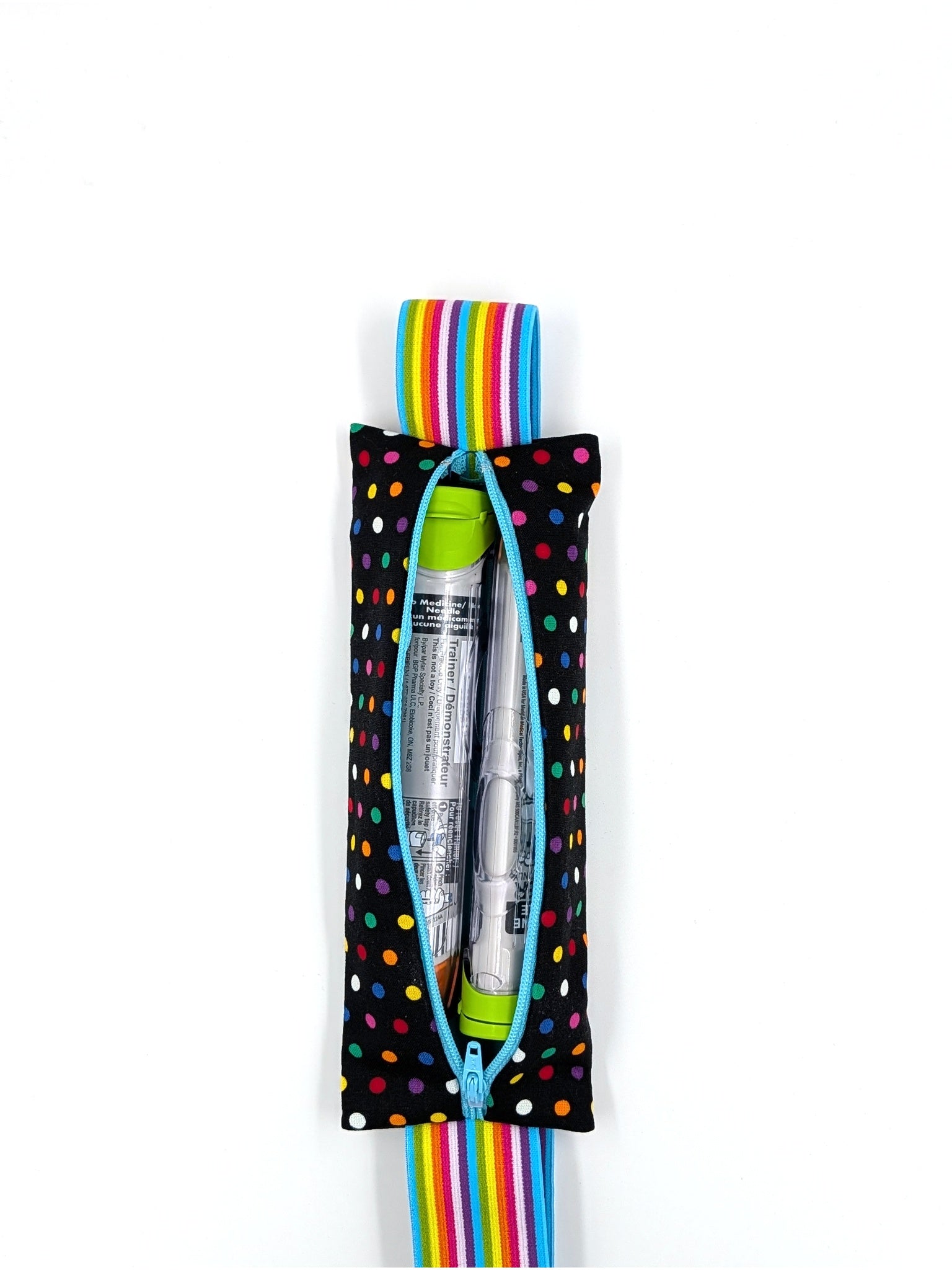 The Daydreamer EpiPen pouch in a black confetti dot print with the rainbow elastic strap, open with an auto-injector and an Emerade inside