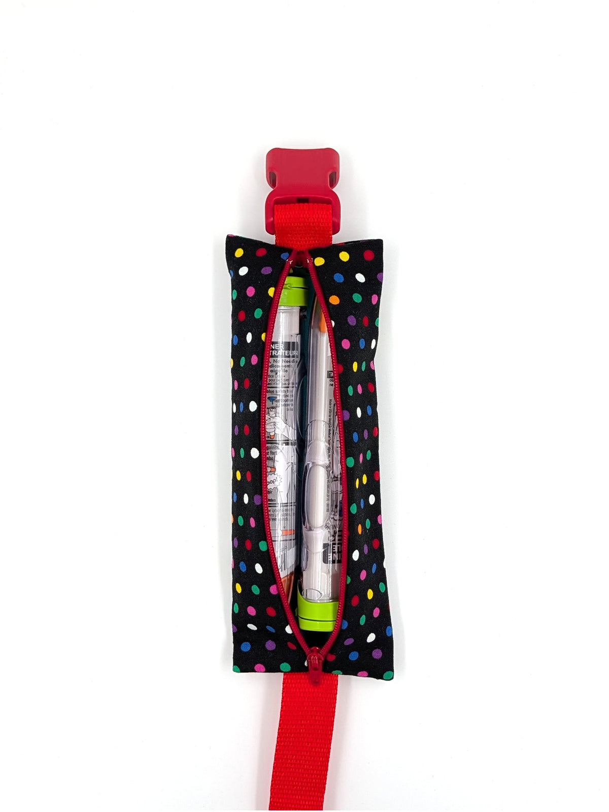 The Daydreamer EpiPen pouch in a black confetti dot print with the red adjustable belt, open with an auto-injector and an Emerade inside