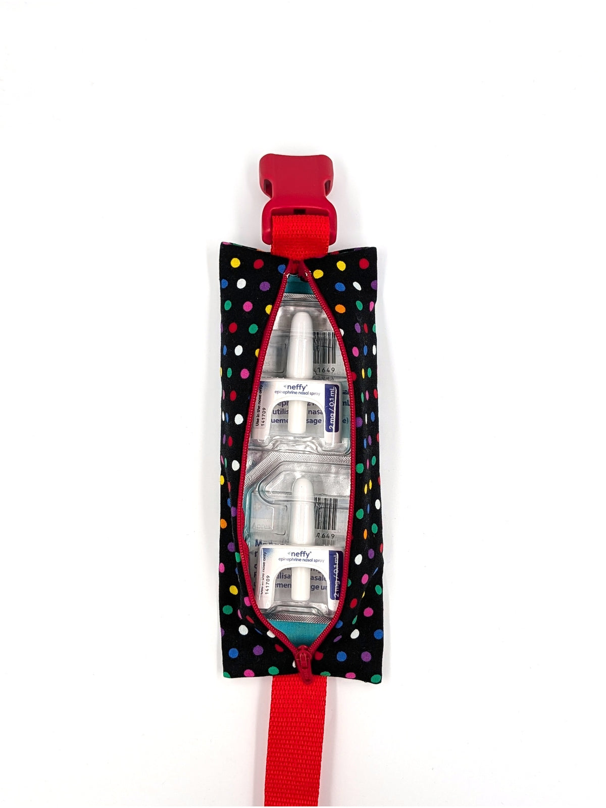 The Daydreamer EpiPen pouch in a black confetti dot print with the red adjustable belt, open with two neffy nasal spray doses inside
