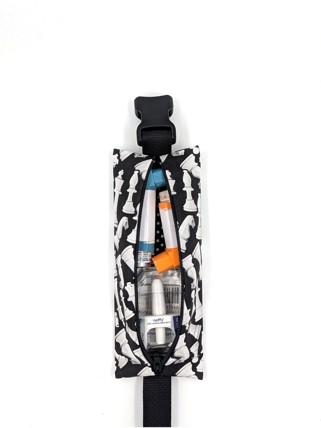 The Grand Master EpiPen pouch in a black and white chess print, open with a mix of allergy medication inside
