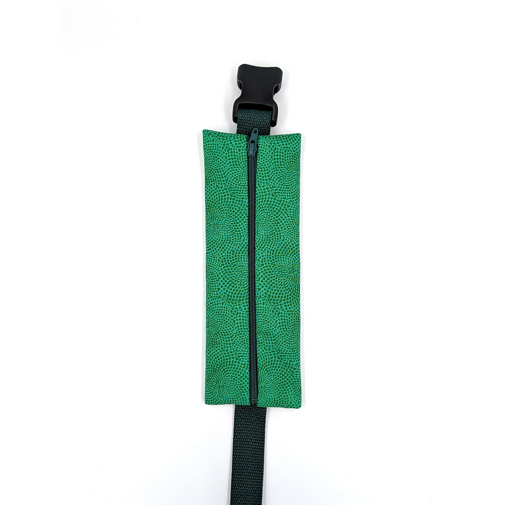 The Scout EpiPen pouch in an emerald green starburst print, closed, shown with its adjustable belt
